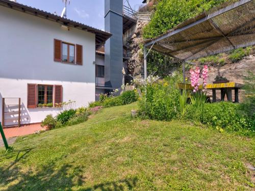 a garden with flowers and a white house at Wonderful flat with swimming pool, lift and garden in Gravedona