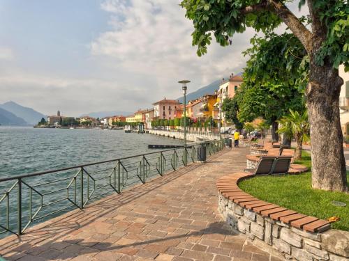 a sidewalk next to a body of water at Wonderful flat with swimming pool, lift and garden in Gravedona