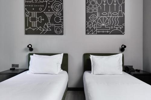 two beds sitting next to each other in a room at Sapiens Hotel in Tashkent