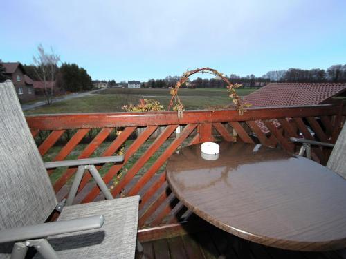 a wooden table and chair on a deck with a table and a table at Apartments Spreewaldperle, Alt Zauche in Alt Zauche