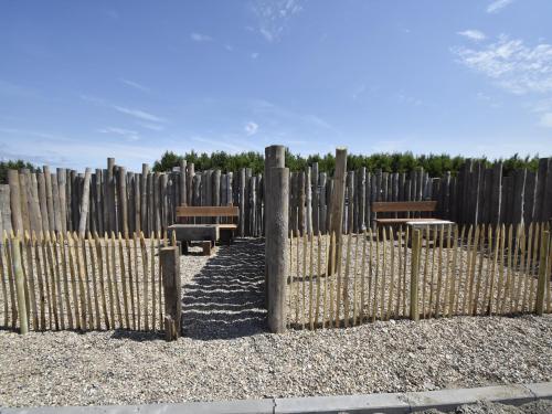 a fence with benches in front of a wooden fence at Studio Hazenborgh in Callantsoog near the sea in Callantsoog