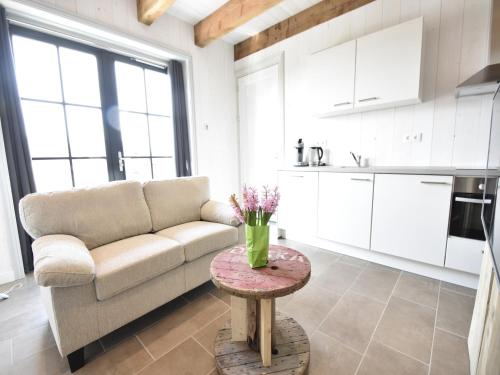 a living room with a couch and a table at Studio Hazenborgh in Callantsoog near the sea in Callantsoog