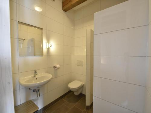 a white bathroom with a toilet and a sink at Studio Hazenborgh in Callantsoog near the sea in Callantsoog
