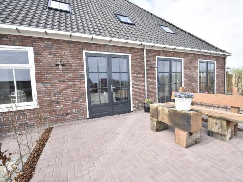 a patio with a bench and a brick building at Studio Hazenborgh in Callantsoog near the sea in Callantsoog