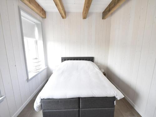 a bed in a room with a window at Studio Hazenborgh in Callantsoog near the sea in Callantsoog
