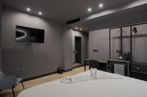 a bedroom with a bed and a television on the wall at Hotel LIVVO La Escarlata in Las Palmas de Gran Canaria