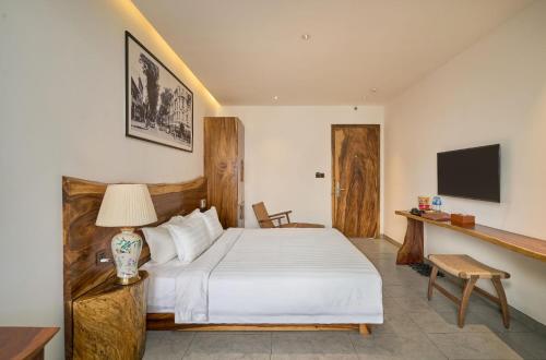 a bedroom with a white bed and a television at Sky Gem Central Hotel in Ho Chi Minh City
