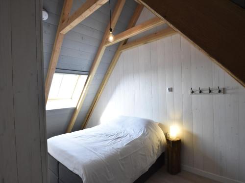 a bedroom with a bed in a attic with a window at Studio Hazenborgh in Callantsoog near the sea in Callantsoog