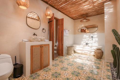 a bathroom with a toilet and a sink and a tub at Layla Cabana - 7BR Villa in Pererenan - With Private Pool, Spa, Cinema & Gym in Tumbak Bayuh