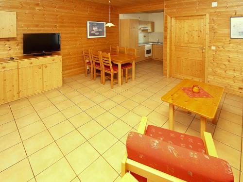 a living room with a table and a kitchen at Harz Holiday Park, Hasselfelde in Hasselfelde