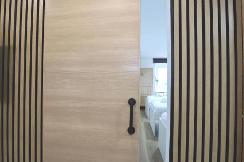 ajar door of a bathroom with a bed in a room at Notel Club - Apt Somo Surf in Somo