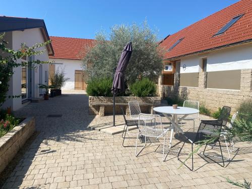 a patio with a table and chairs and an umbrella at Ferienwohnung Wulkatal 