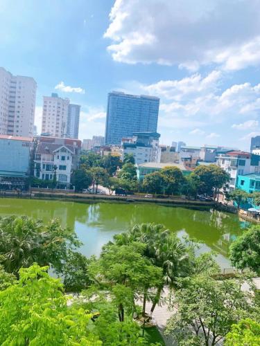 a city skyline with a pond in the foreground at Sunny Hotel in Hanoi