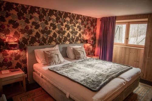 a bedroom with a bed in a room with floral wallpaper at Chalet de luxe - Alpes française in Colmars