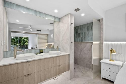 ヌーサヘッズにあるFrench Quarter by Stay Noosaの洗面台2つとシャワー付きのバスルーム