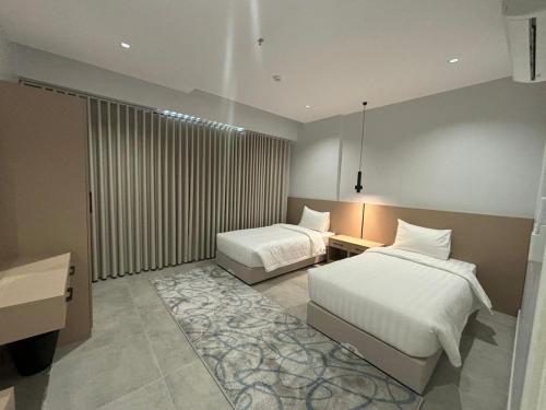 a bedroom with two beds and a rug in it at اجنحة راف بني حارثة in Medina