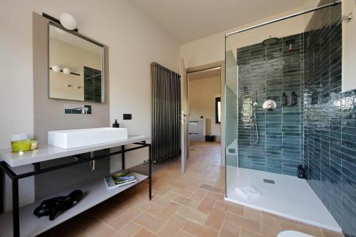 a bathroom with a sink and a glass shower at The Monteleone Umbria Retreat in Monteleone dʼOrvieto