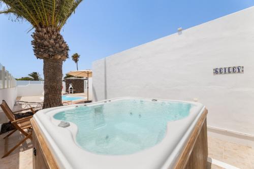 un jacuzzi avec un palmier sur une terrasse dans l'établissement Casa Keiley by EscapeHome, à Puerto del Carmen