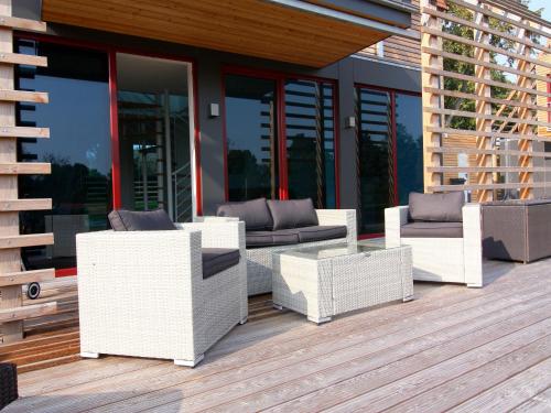 a deck with white wicker furniture on a building at Chalet, Wendorf in Wendorf