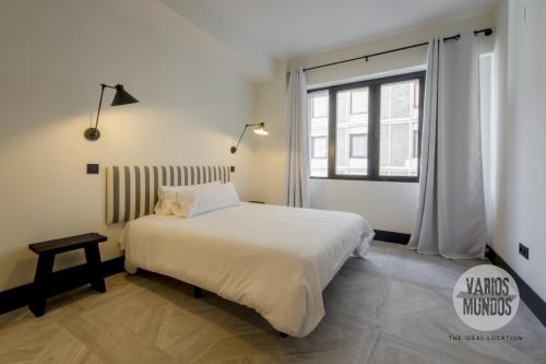 ein Schlafzimmer mit einem weißen Bett und einem Fenster in der Unterkunft Un Madrid histórico para 4, en Plaza del Carmen E2 in Madrid