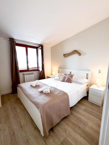 a bedroom with a large white bed and a window at Casa Romeo - Sea View Apartment in Focene