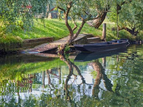 a boat parked next to a dock in the water at Bungalow in Lübben with a terrace in Lübben