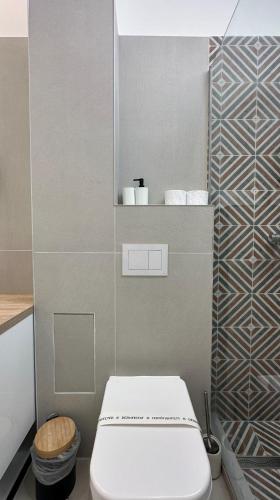 a bathroom with a white toilet in a room at ELIZA Apartments - powered by NEO - private parking in Timişoara