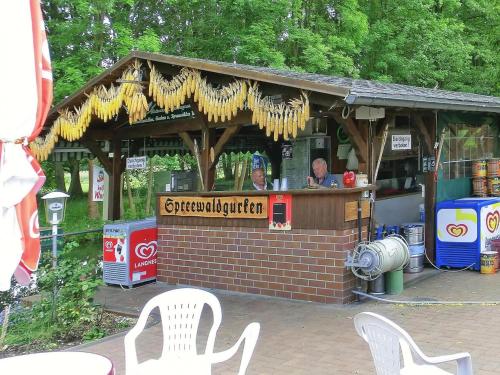 a food cart with two men sitting at the bar at Bungalow in Lübben with a terrace in Lübben