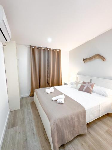a bedroom with a large bed with towels on it at Casa Romeo - Sea View Apartment in Focene
