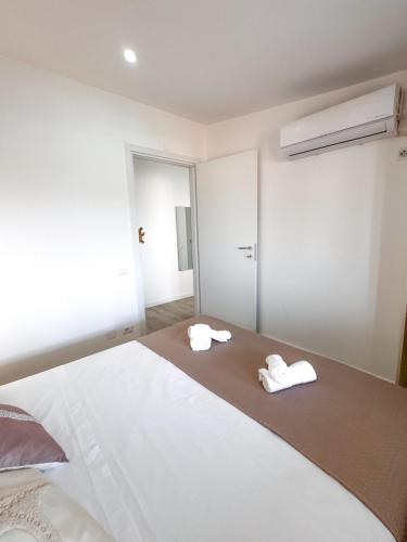 a bedroom with two white towels on a bed at Casa Romeo - Sea View Apartment in Focene