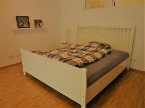 a white bed with a plaid blanket on it at K9 Wohnungen in Münster