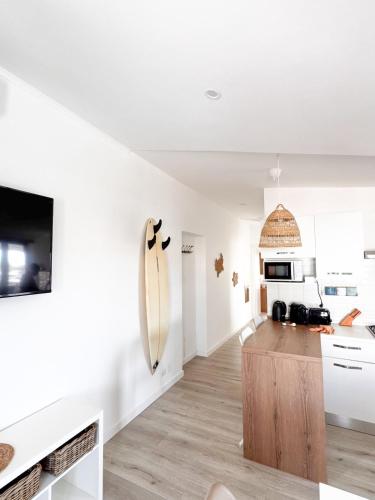 a white kitchen with a surfboard on the wall at Casa Romeo - Sea View Apartment in Focene