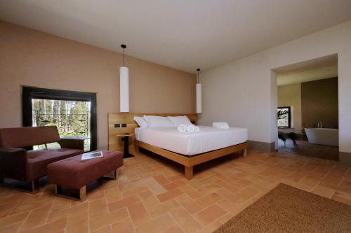 a bedroom with a bed and a chair and a tub at The Monteleone Umbria Retreat in Monteleone dʼOrvieto