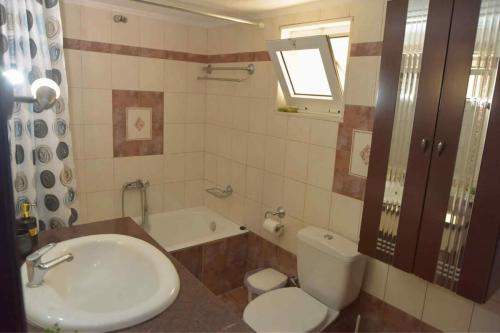 a bathroom with a sink and a toilet and a tub at Sunshine Apartment in Alexandroupoli