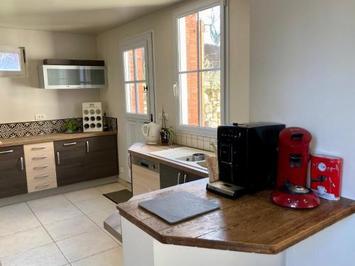 a kitchen with a red appliance on a wooden counter at L'Auberge des Clés in Chevannes