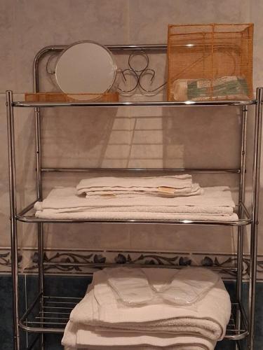 a metal shelf with towels and a pair of scissors at Espe Daga Apartamento in Bueu
