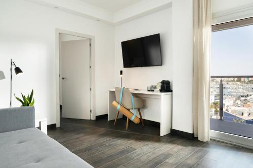 a hotel room with a desk and a tv on the wall at INNSiDE by Meliá Alicante Porta Maris in Alicante