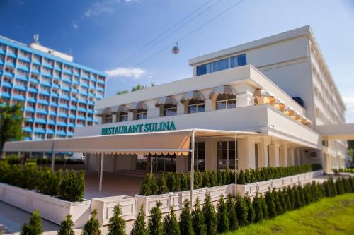 a building with a sign that reads restaurant shinka at Hotel Sulina International in Mamaia