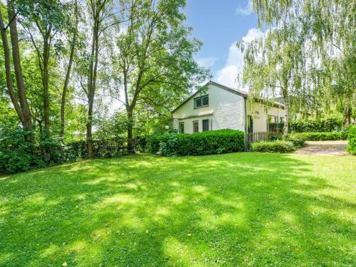 a yard with a white house and trees at Serene Holiday Home in Ulestraten with Terrace in Ulestraten