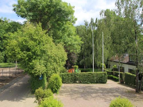 a park with bushes and trees and a building at Serene Holiday Home in Ulestraten with Terrace in Ulestraten