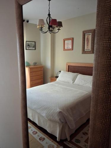 a mirror reflecting a bedroom with a bed and a dresser at Espe Daga Apartamento in Bueu