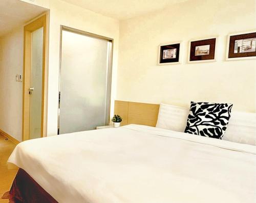 a bedroom with a large white bed with a pillow at Wemeet Hotel Taipei in Taipei