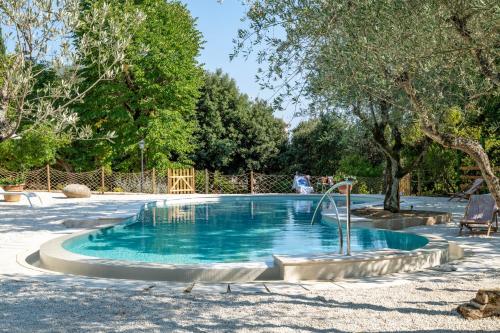 a swimming pool with a fountain in a yard at Nobilis Charme Relais in Montepulciano