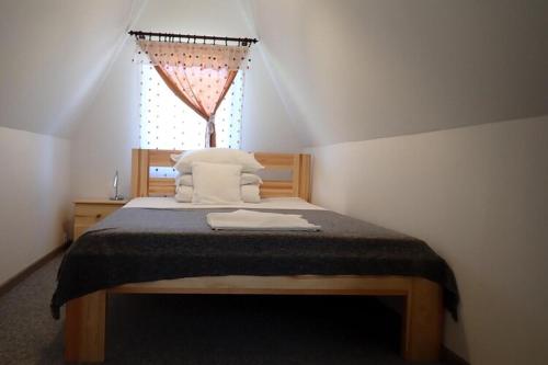 ein Schlafzimmer mit einem Bett mit Kissen und einem Fenster in der Unterkunft Bungalow in Kolczewo with parking space in Kołczewo