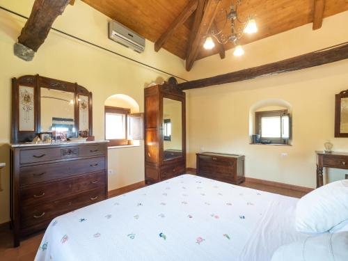 a bedroom with a bed and a dresser and mirror at Ancient holiday home in the countryside of Stilo with garden in Guardavalle