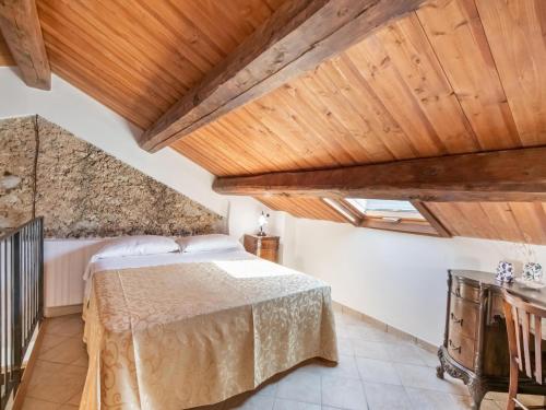 a bedroom with a bed and a wooden ceiling at Ancient holiday home in the countryside of Stilo with garden in Guardavalle