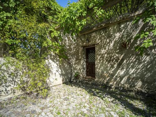 a door in the side of a stone wall with trees at Ancient holiday home in the countryside of Stilo with garden in Guardavalle