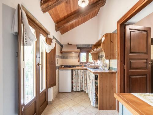 a kitchen with wooden cabinets and a white refrigerator at Ancient holiday home in the countryside of Stilo with garden in Guardavalle