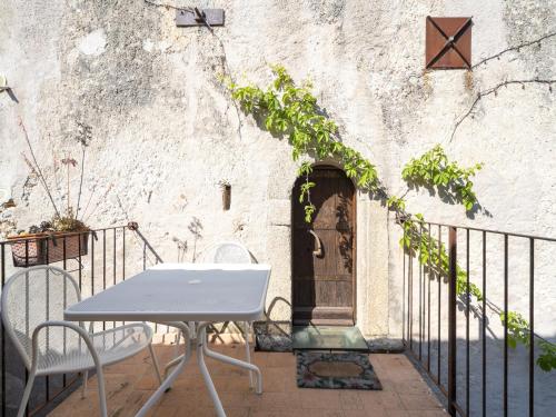 a table and chairs in front of a wall at Ancient holiday home in the countryside of Stilo with garden in Guardavalle