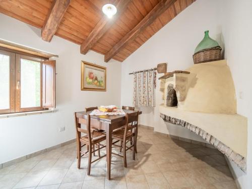 a dining room with a table and a wood stove at Ancient holiday home in the countryside of Stilo with garden in Guardavalle